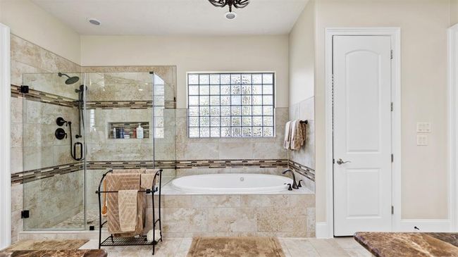 Large frameless shower has a seat and 2 shower heads. | Image 34