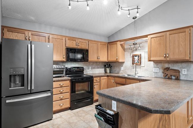 The kitchen features rich wooden cabinetry with abundant storage/prep space! | Image 8