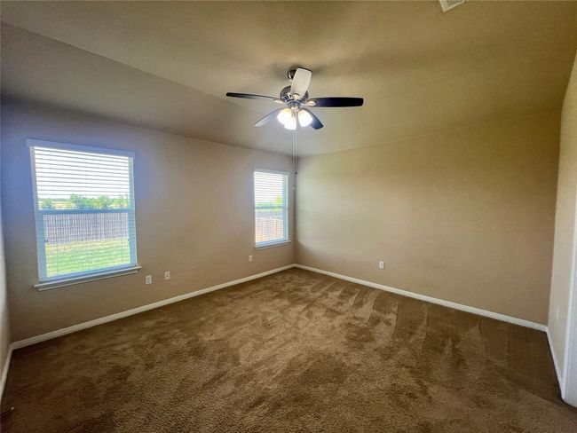 Carpeted primary bedroom with baseboards and a ceiling fan | Image 12