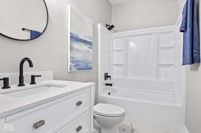full bathroom featuring marble finish floor, toilet, vanity, and shower / tub combination | Image 33