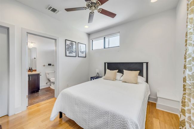 Bedroom featuring hardwood / wood-style floors, ensuite bath, and ceiling fan | Image 25