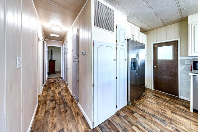The side door and the hallway to the bedrooms. | Image 25
