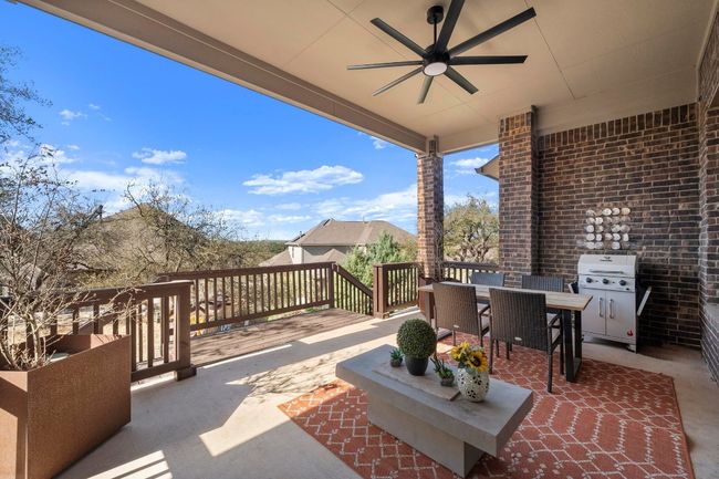 This covered back patio is elevated and breezy with its' oversized ceiling fan and extra room for outside plants and BBQ grill. | Image 36