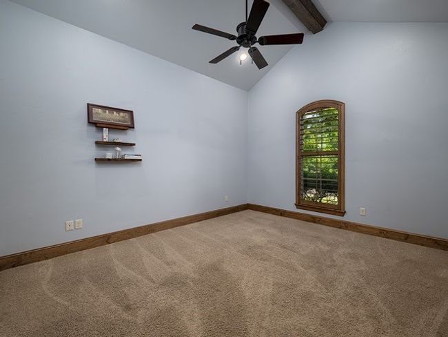 Spare room featuring ceiling fan, baseboards, carpet flooring, and beam ceiling | Image 24