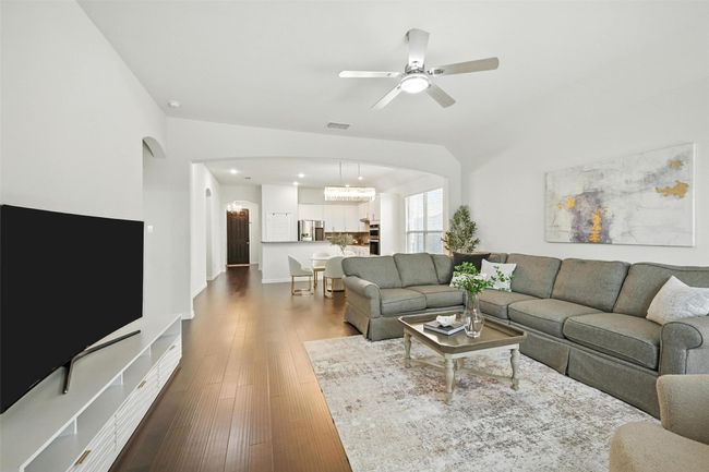 Living area featuring dark wood-type flooring, arched walkways, recessed lighting, and a ceiling fan | Image 15