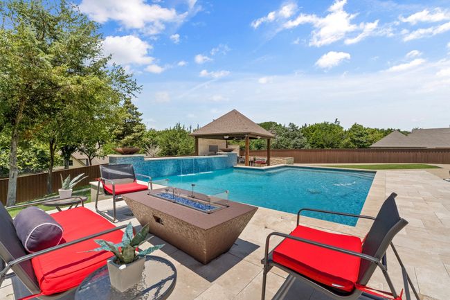 View of pool featuring a gazebo, an outdoor fire pit, a patio area, and a fenced backyard | Image 34