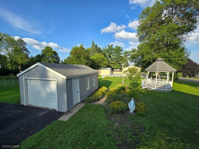 Views of the adorable garage with side windows, and gazebo that sits in the middle of the backyard. | Image 4