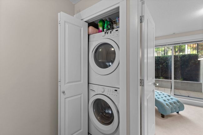 Washroom with carpet floors, stacked washer / dryer, and laundry area | Image 21
