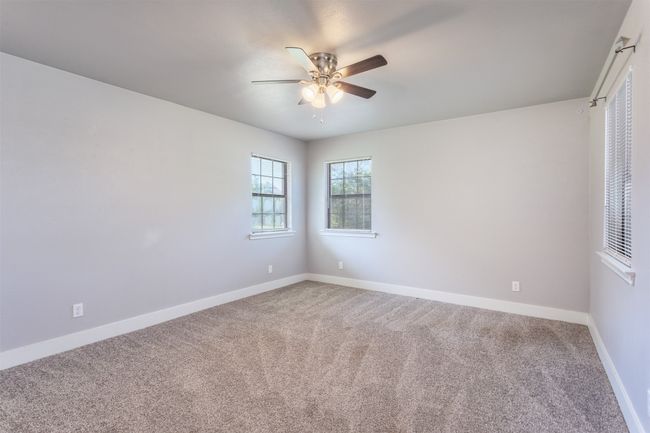 Carpeted empty room with baseboards and ceiling fan | Image 22