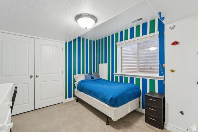Carpeted bedroom with wallpapered walls, a closet, and a climbing wall | Image 32