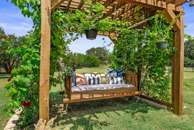 Relax in a tranquil pergola, where a daybed is nestled beneath a canopy of fragrant roses & lush grapevines. | Image 29