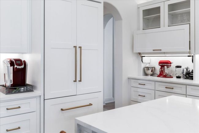 Kitchen with white cabinetry, light countertops, and glass insert cabinets | Image 10