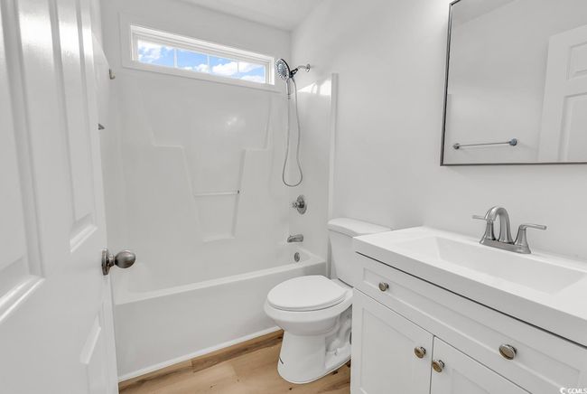 Bathroom featuring shower / bath combination, wood finished floors, toilet, and vanity | Image 18
