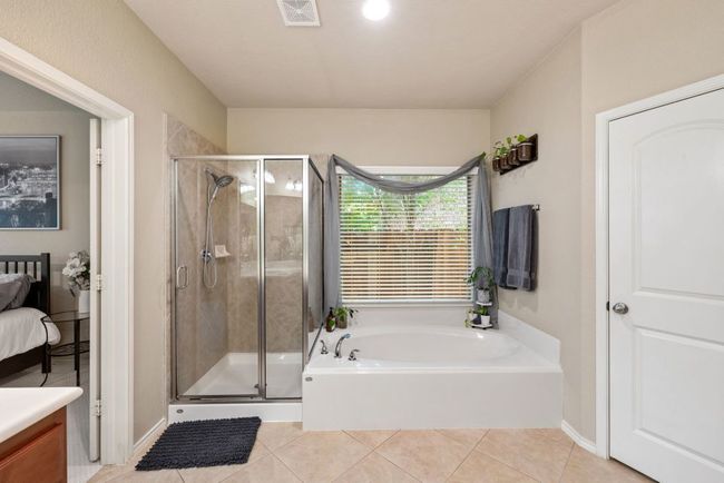 Bathroom with a garden tub, tile patterned flooring, a shower stall, vanity, and ensuite bath | Image 17