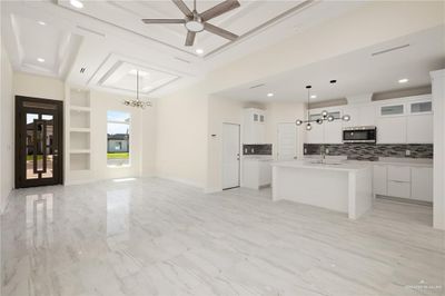 Living room with built in features, sink, and ceiling fan with notable chandelier | Image 2