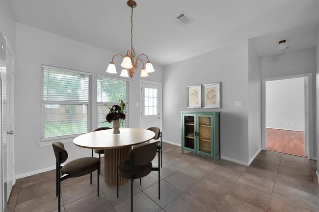 Most windows have been upgraded with energy efficient window screens. The back door was also recently replaced. To the right you'll find the hallway to the primary bedroom, half bath, and laundry room.*Virtually staged | Image 15