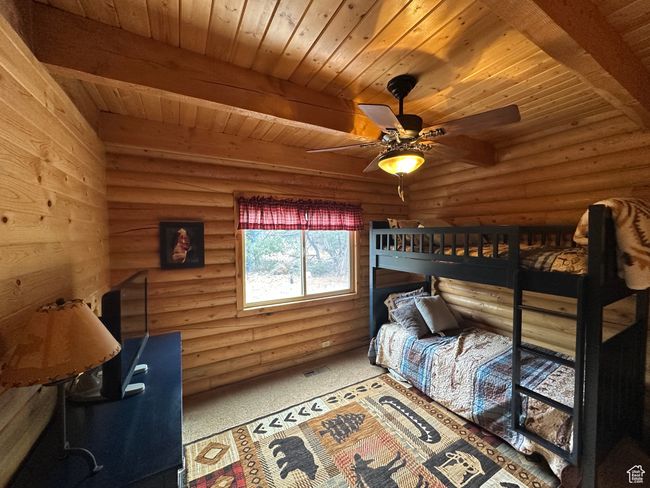 Bedroom with wooden ceiling, rustic walls, and beam ceiling | Image 16