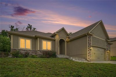 View of front facade with a garage and a lawn | Image 2