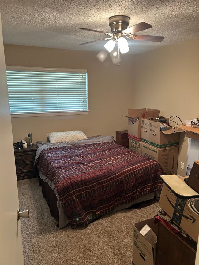 Bedroom with carpet floors, a ceiling fan, and a textured ceiling | Image 15