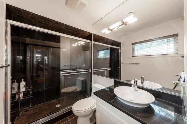 Bathroom with vanity, toilet, a stall shower, and tile patterned flooring | Image 21