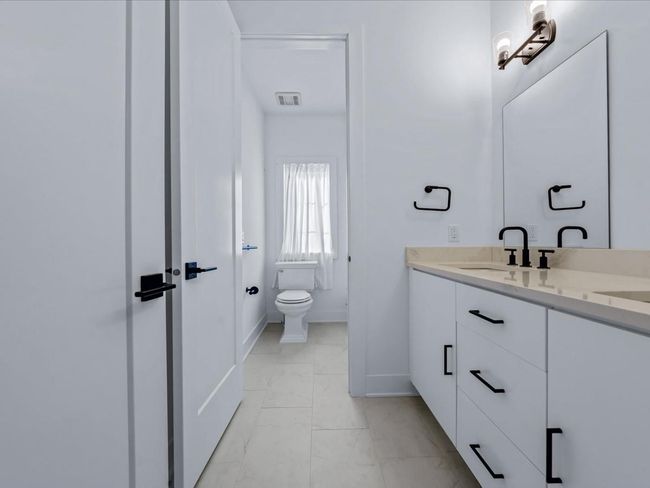 Bathroom with visible vents, baseboards, marble finish floor, toilet, and vanity | Image 17