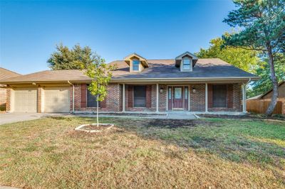 View of front of property with a porch, a front lawn, and a garage | Image 2