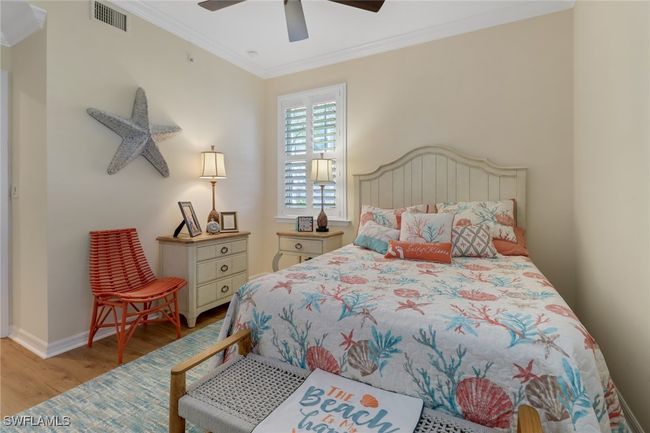 Bedroom featuring visible vents, baseboards, ornamental molding, ceiling fan, and wood finished floors | Image 17