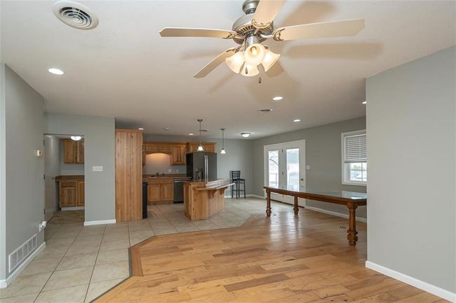 Kitchen with visible vents, a center island, ceiling fan, light wood-type flooring, and fridge with ice dispenser | Image 7