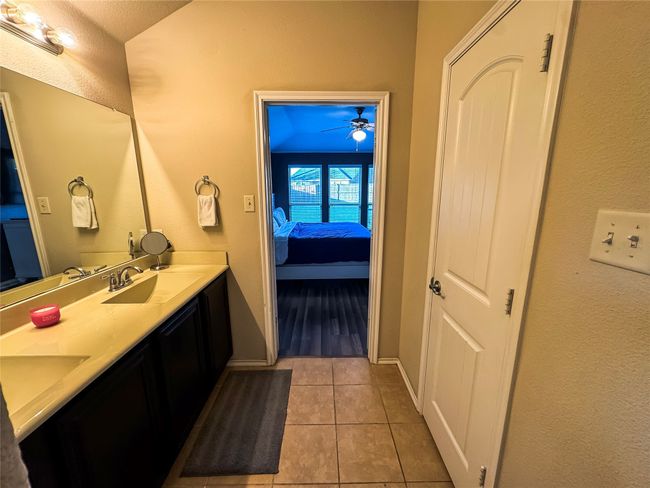 Full bathroom featuring ceiling fan, ensuite bathroom, a sink, tile patterned floors, and double vanity | Image 18