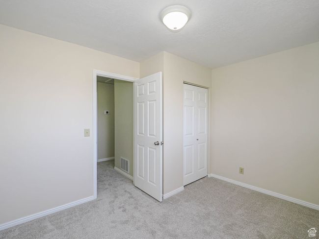Unfurnished bedroom featuring light colored carpet and a closet | Image 45