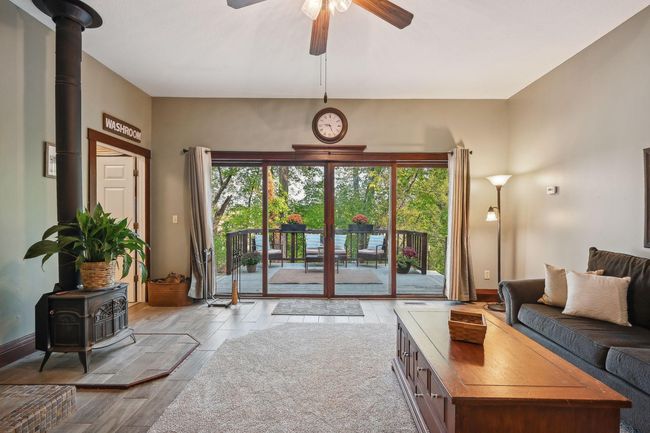 The family room, 17x17 with an 8x9 nook to the left (step up), has been updated with a free-standing wood stove, new tile, and brand-new carpet. It has beautiful views of the back (North) over Stanchfield Creek. | Image 19