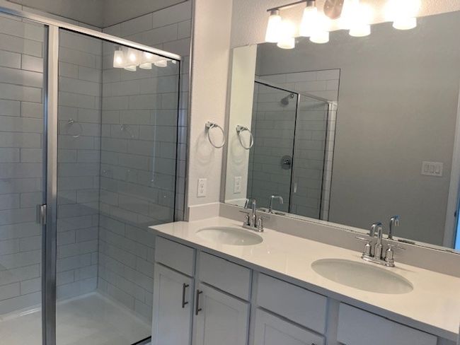 Bathroom with a stall shower and double vanity | Image 8