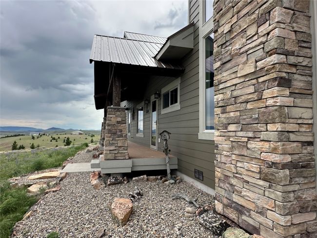 View of side of property featuring crawl space and stone siding | Image 32