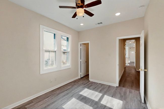 Unfurnished bedroom with wood finished floors, baseboards, recessed lighting, and ceiling fan | Image 6