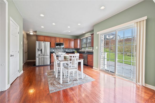 The spacious kitchen includes hardwood floors and a sliding glass door that leads to the deck and patio. | Image 4