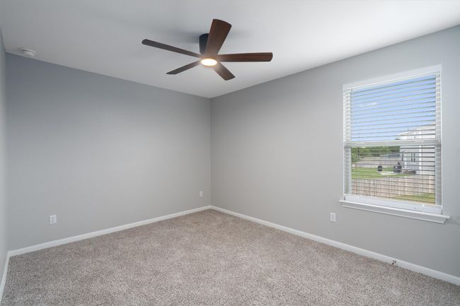 Carpeted spare room featuring a smoke detector and ceiling fan | Image 22