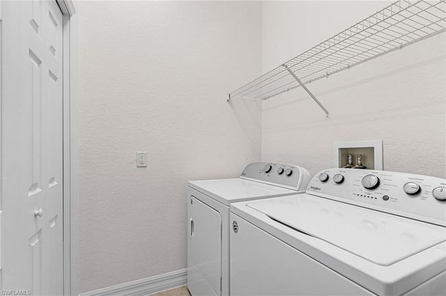 Laundry area with separate washer and dryer and a textured wall | Image 20