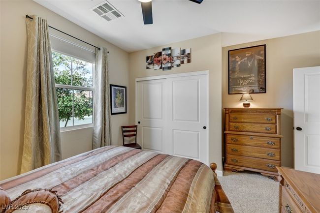 Bedroom featuring a ceiling fan, a closet, and visible vents | Image 32