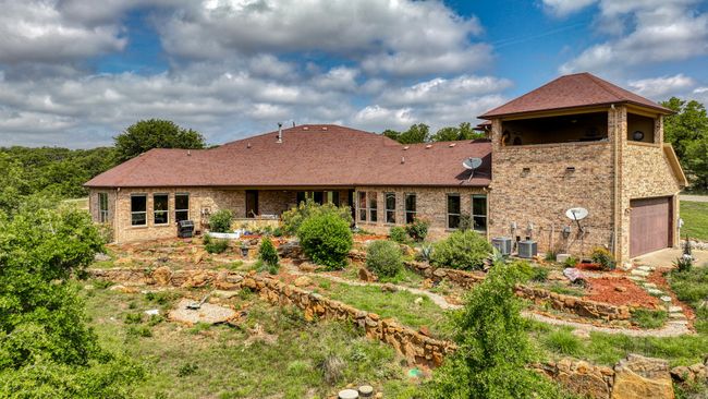 Back of house with brick siding, central AC unit, a garage, and a shingled roof | Image 37