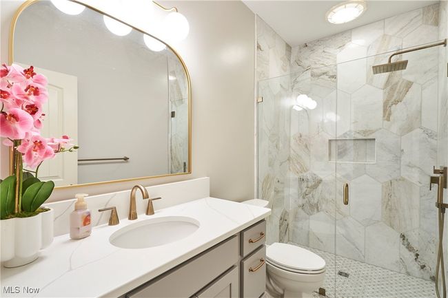 Each bedroom has a private bath. This bathroom is newly remodeled with marble shower, marble floor, new cabinet, and quartz counter top | Image 19