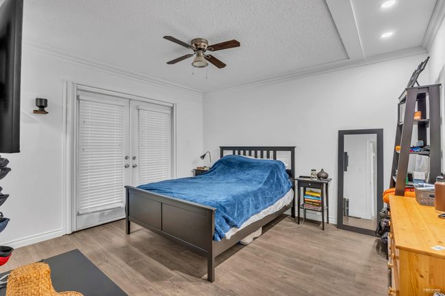 Bedroom with wood finished floors, crown molding, recessed lighting, and a ceiling fan | Image 17