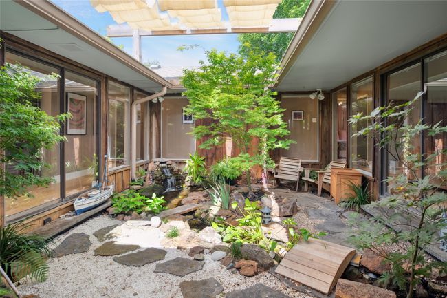 Shaded and serene atrium provides a tranquil rest spot center of the home. | Image 6