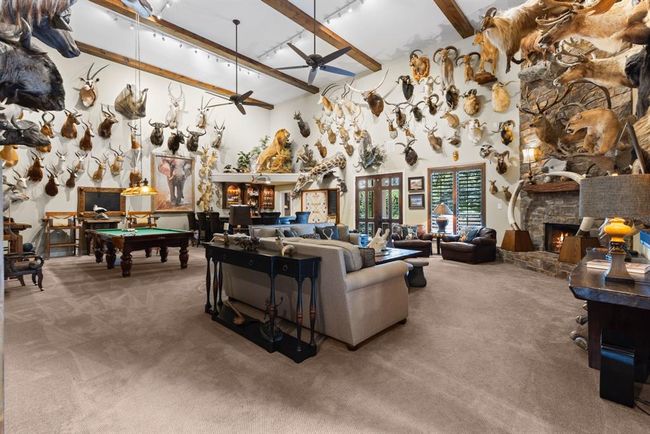 This is a one-of-a-kind trophy or large entertainment room located downstairs in the home. The room itself is two stories and is perfect for all your social gatherings! And the grand focal point is a two story stone stacked fireplace - WOW! | Image 27