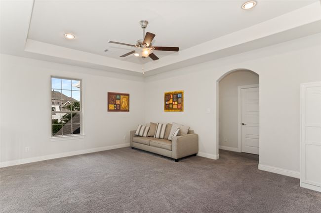 Living area with ceiling fan, arched walkways, carpet floors, a raised ceiling, and recessed lighting | Image 25