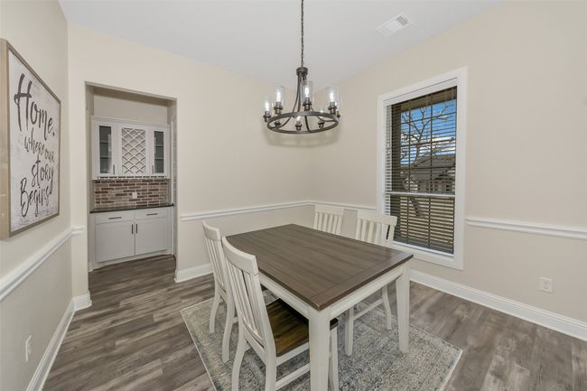 Dining area featuring an inviting chandelier, baseboards, visible vents, and dark wood-style flooring | Image 4