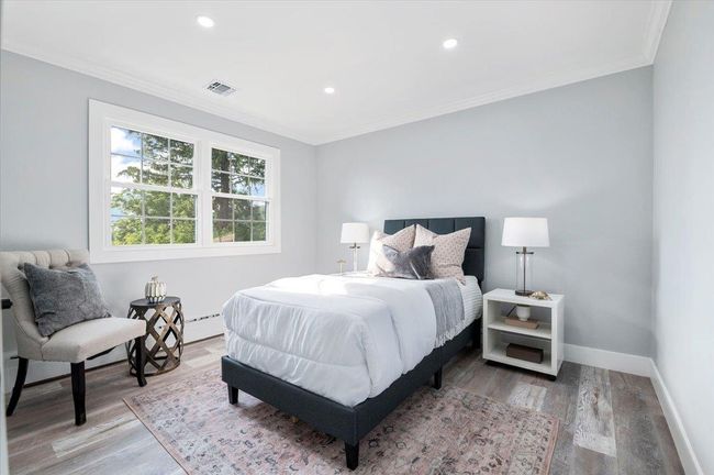 Bedroom with crown molding, wood finished floors, recessed lighting, and a baseboard radiator | Image 17