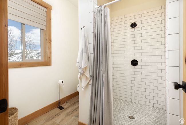 Bathroom with a shower stall, baseboards, toilet, and wood finished floors | Image 21
