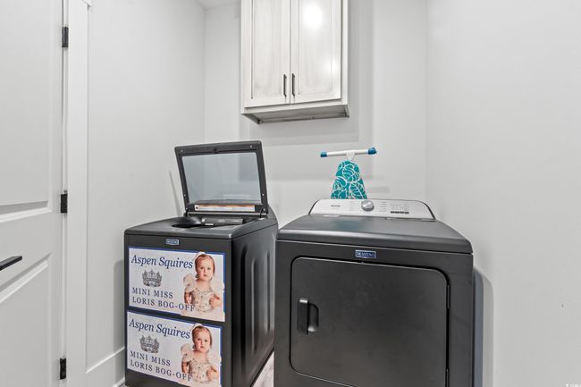 Washroom featuring cabinet space and washing machine and dryer | Image 28