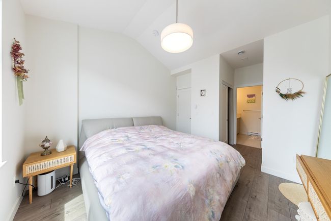 Bedroom with wood finished floors, lofted ceiling, baseboards, and a baseboard radiator | Image 12