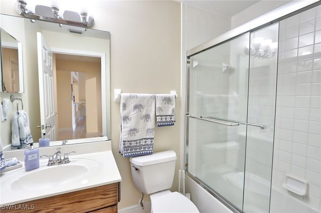 Full bathroom with enclosed tub / shower combo, vanity, and toilet | Image 18